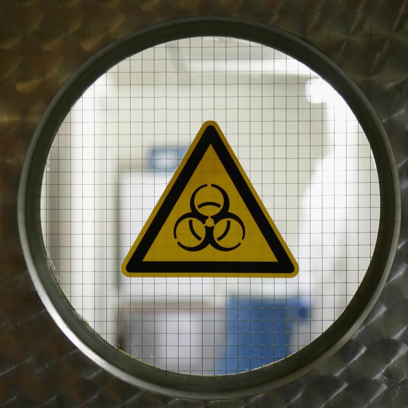 Yellow biohazard sign in a door window